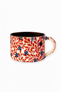 Decorative mug with red floral pattern on a white background